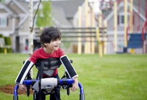 Disabled boy in walker in front of playground