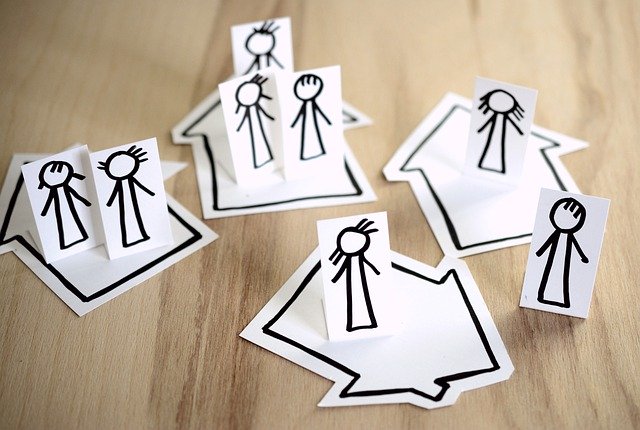 Paper cut of people standing on their houses